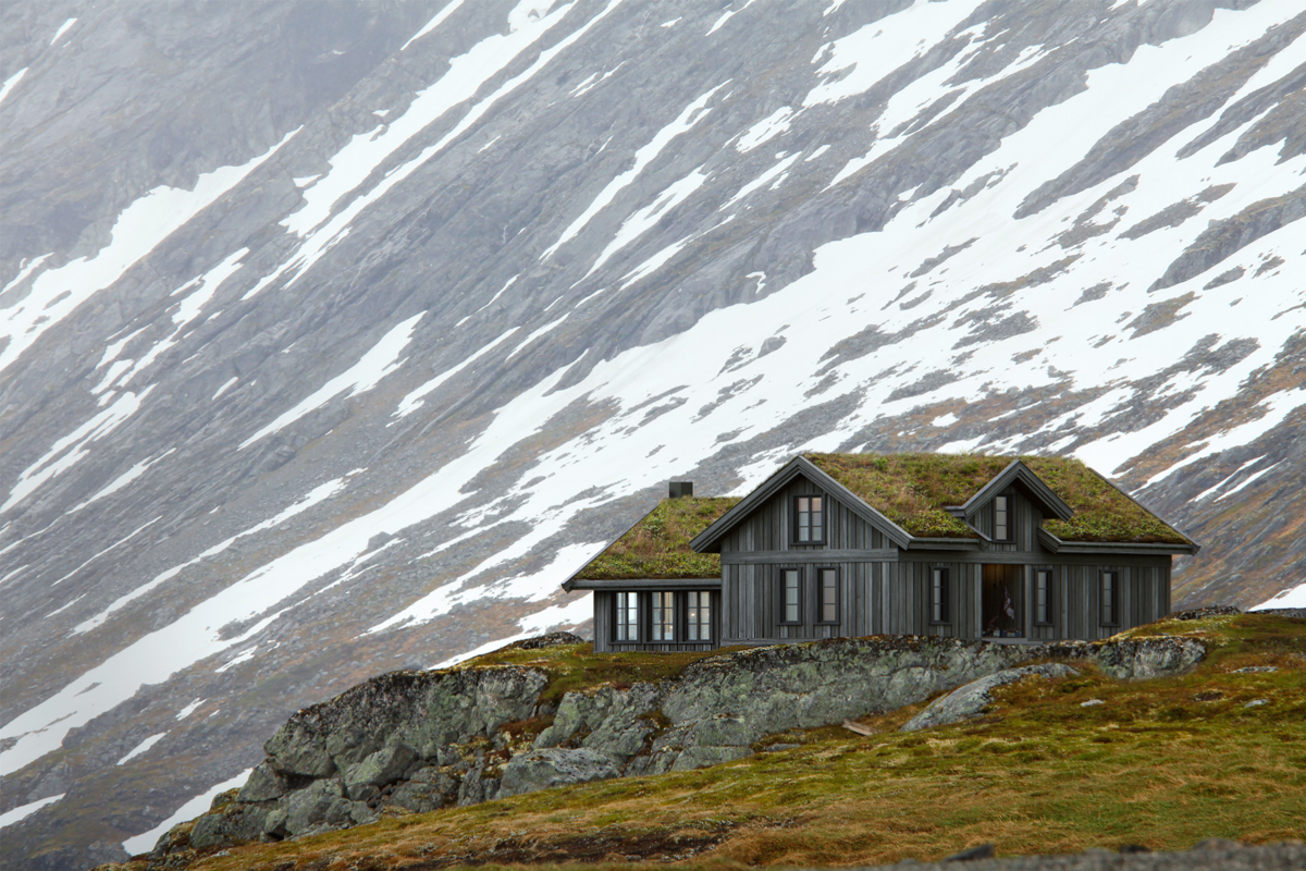 En robust hytte står ved foten av et snødekt fjell